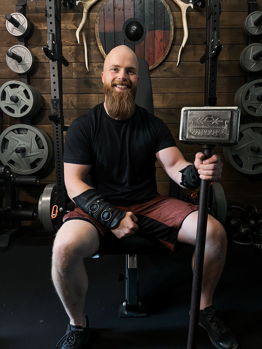 The coach is smiling while sitting at the gym.
