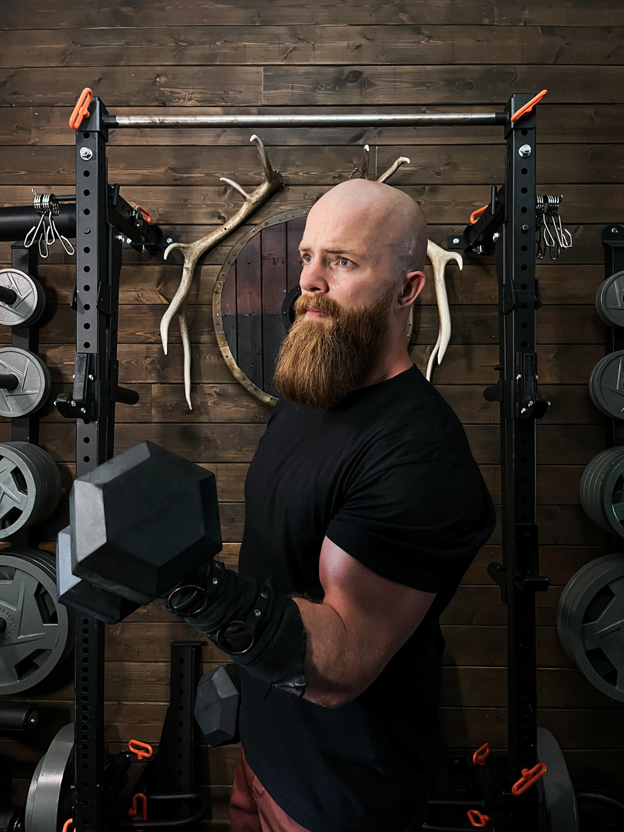 The coach is holding the dumbbell.